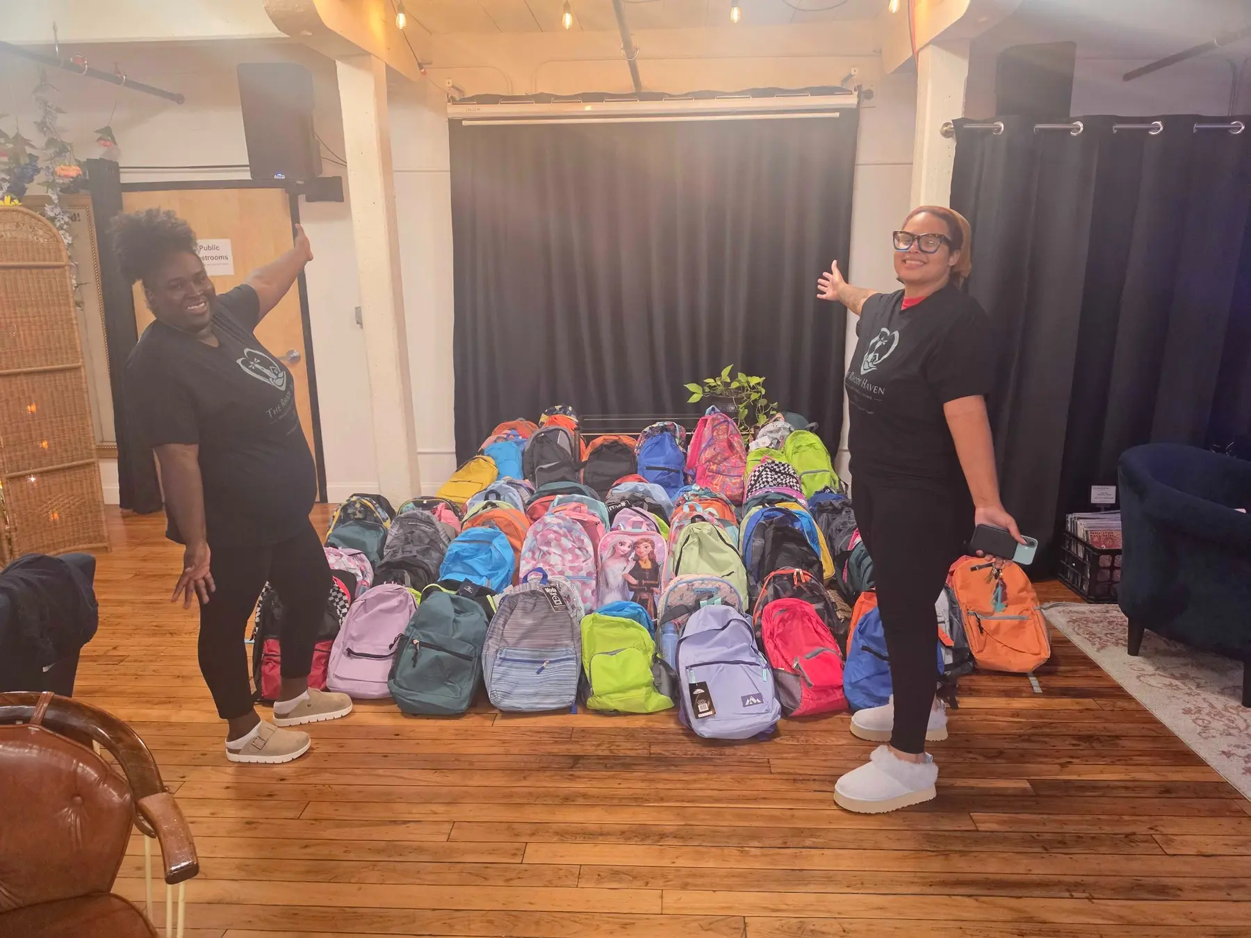 Rhody Haven volunteers standing beside rows of donated backpacks